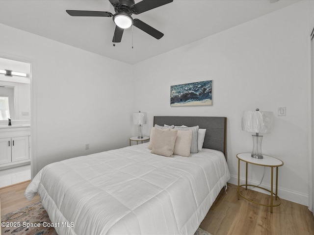 bedroom with connected bathroom, ceiling fan, sink, and wood-type flooring