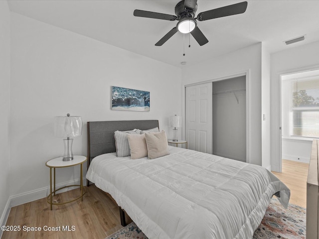 bedroom with hardwood / wood-style flooring, ceiling fan, and a closet