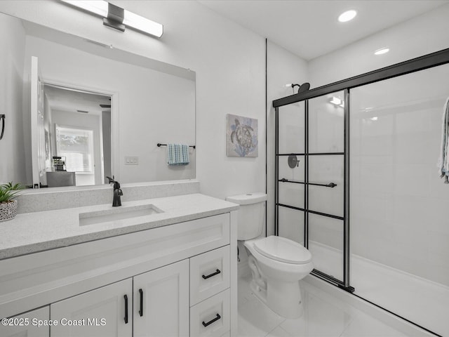 bathroom with a shower with door, vanity, and toilet