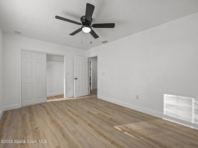 unfurnished bedroom featuring light wood-type flooring, a closet, and ceiling fan