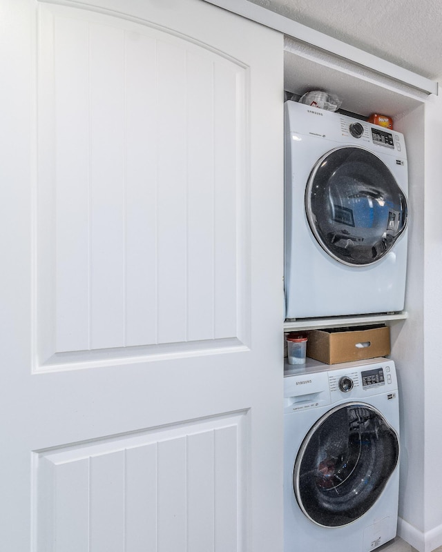 laundry room with stacked washer / dryer and a textured ceiling