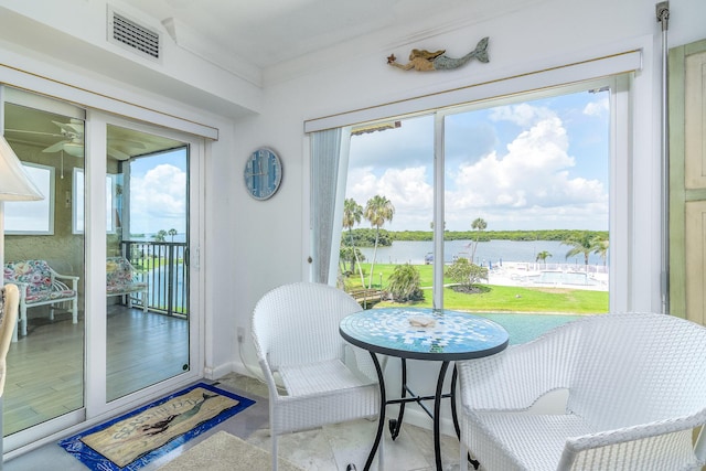 sunroom featuring a healthy amount of sunlight and a water view