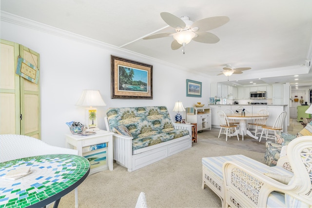 living room with light colored carpet, ceiling fan, and crown molding