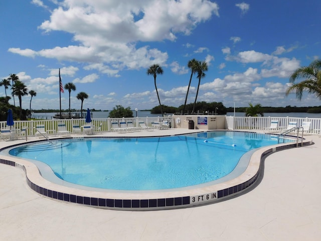 view of pool with a patio area and a water view