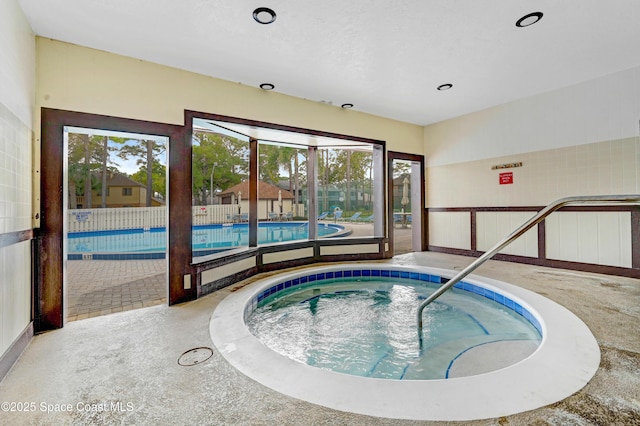 view of swimming pool with an indoor hot tub