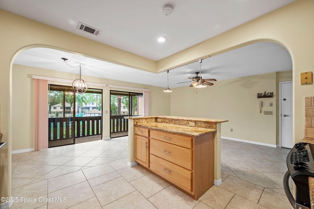 kitchen featuring light stone counters, hanging light fixtures, ceiling fan, and light tile patterned flooring