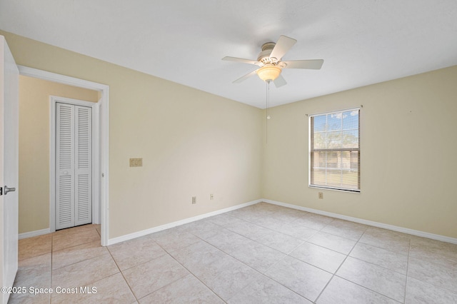 tiled spare room with ceiling fan