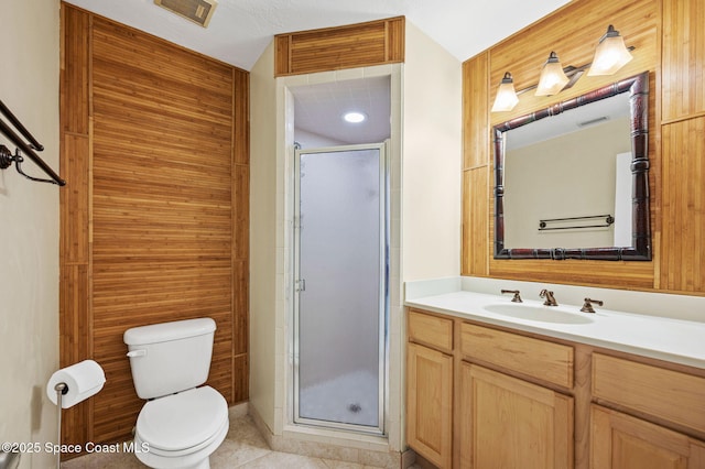 bathroom featuring vanity, toilet, a shower with door, and tile patterned flooring