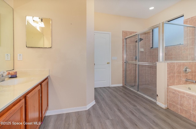 bathroom featuring independent shower and bath, wood-type flooring, and vanity