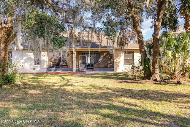 rear view of house with a lawn and a patio