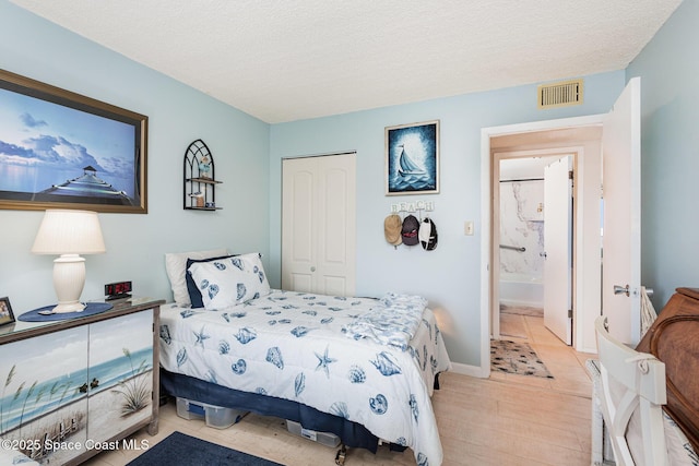 bedroom featuring a closet, light hardwood / wood-style floors, and a textured ceiling