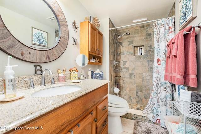 bathroom with tile patterned flooring, vanity, toilet, and walk in shower