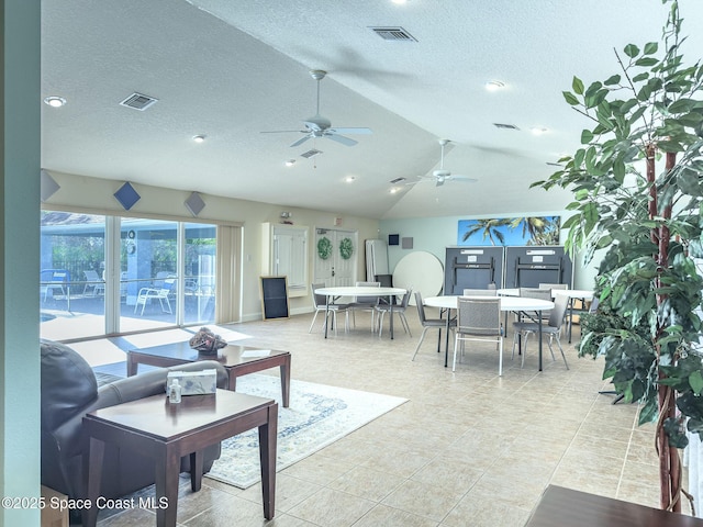 tiled living room featuring ceiling fan, lofted ceiling, and a textured ceiling