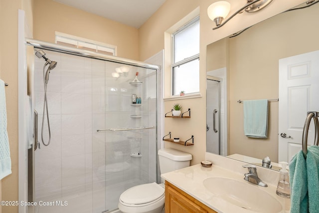 bathroom with vanity, toilet, and a shower with shower door