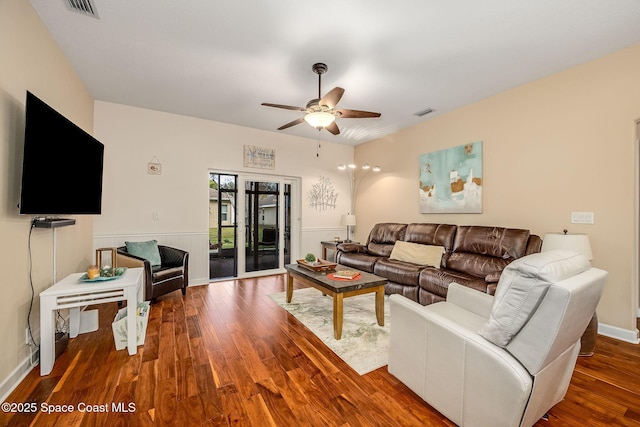 living room featuring ceiling fan and dark hardwood / wood-style flooring