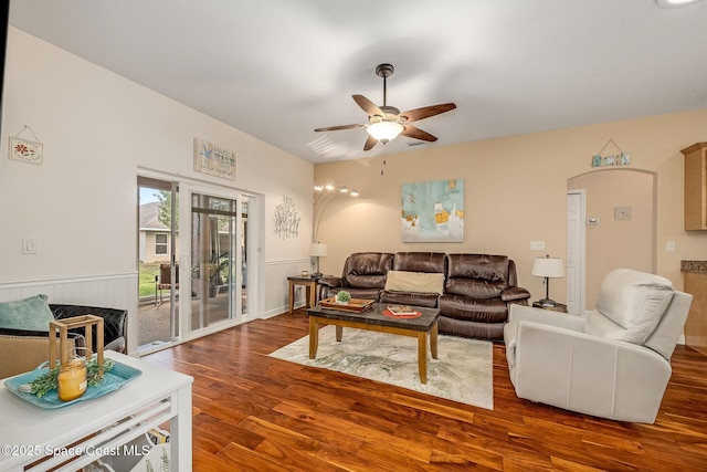 living room with ceiling fan and dark hardwood / wood-style flooring