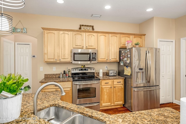 kitchen featuring light stone countertops, sink, light brown cabinets, and appliances with stainless steel finishes