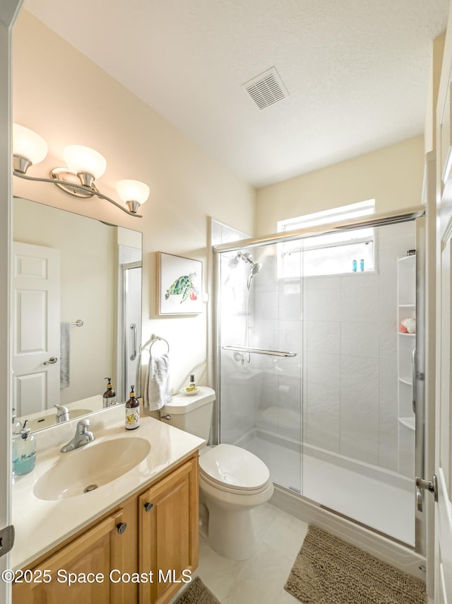 bathroom with tile patterned flooring, vanity, toilet, and an enclosed shower