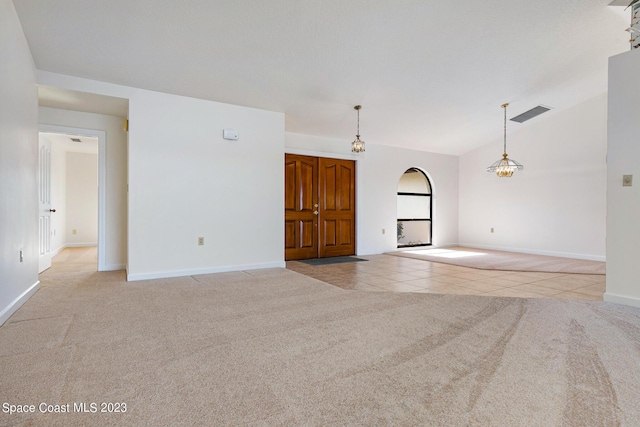 tiled spare room with a chandelier