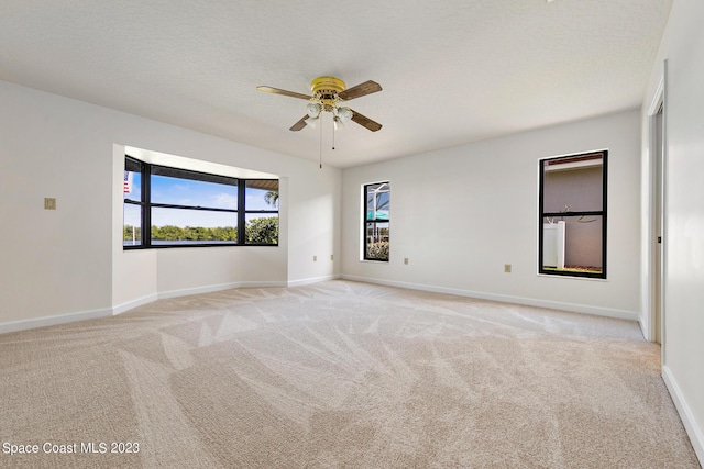 carpeted spare room with a textured ceiling and ceiling fan