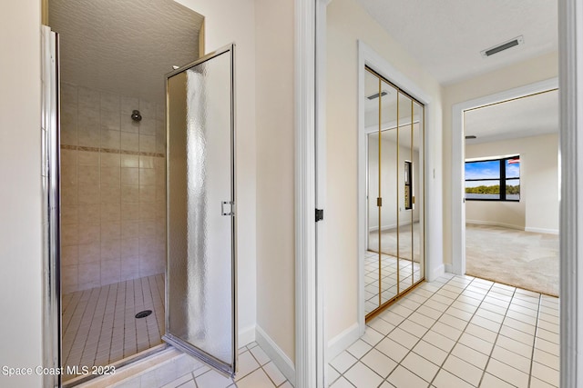 bathroom with tile patterned flooring and walk in shower