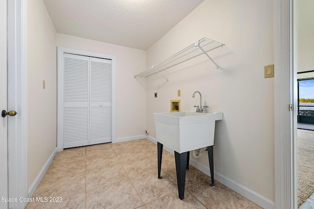 laundry room featuring washer hookup, a textured ceiling, and hookup for an electric dryer