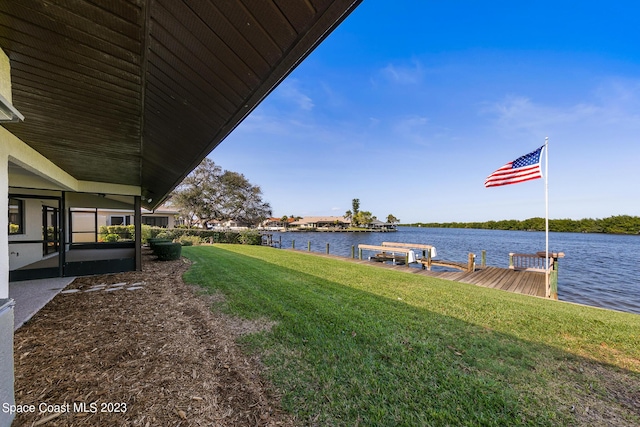 view of yard featuring a dock and a water view