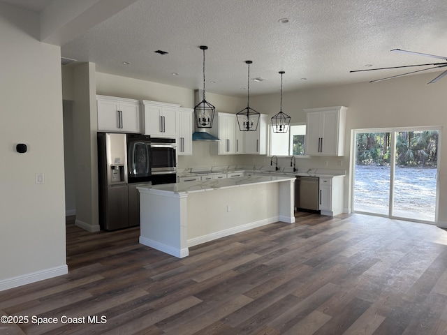 kitchen featuring white cabinetry, hanging light fixtures, dark hardwood / wood-style floors, a kitchen island, and stainless steel appliances