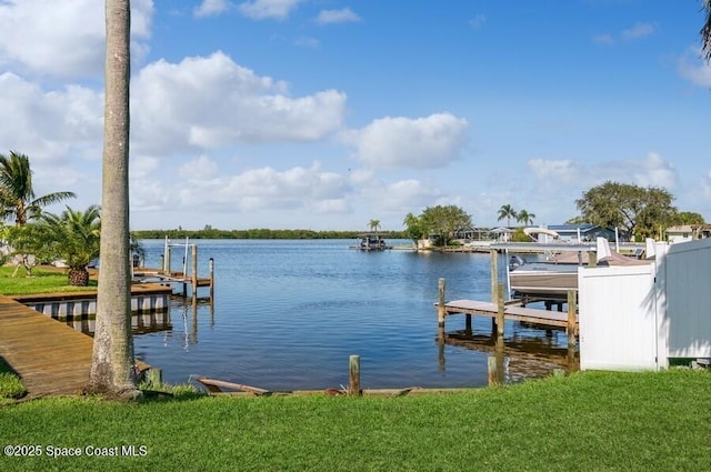 view of dock featuring a lawn and a water view