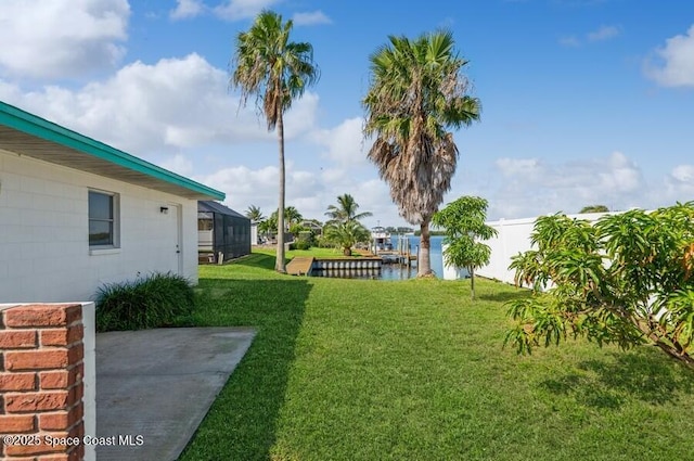 view of yard featuring a patio, a water view, and glass enclosure