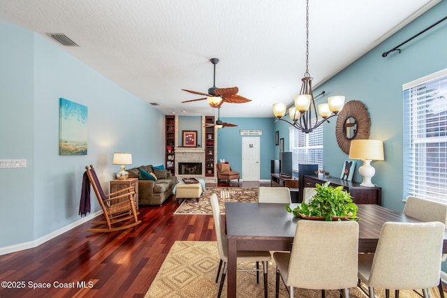 dining area with a textured ceiling, dark wood-type flooring, and ceiling fan with notable chandelier