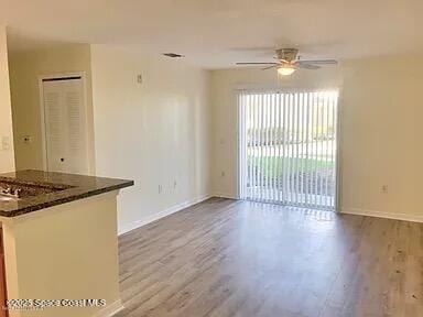 unfurnished living room with hardwood / wood-style floors and ceiling fan