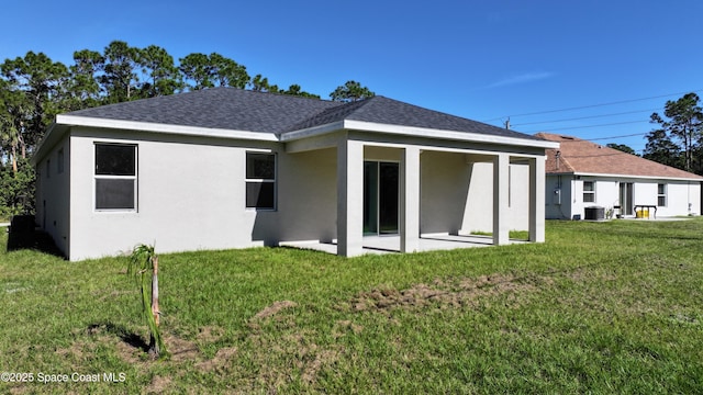 back of house with central AC, a patio area, and a yard