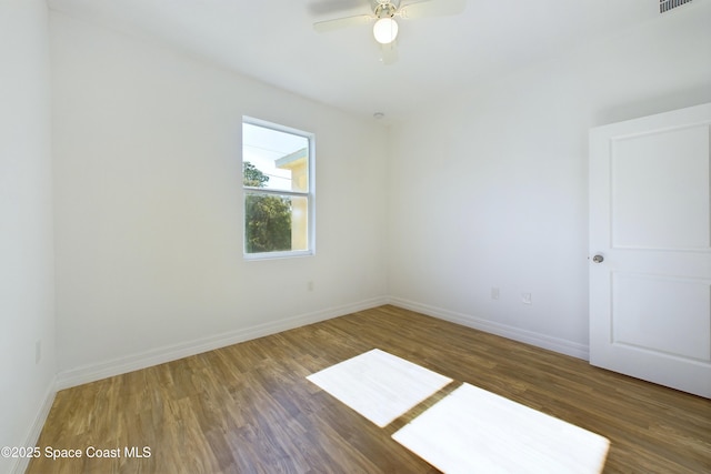 spare room with dark hardwood / wood-style floors and ceiling fan