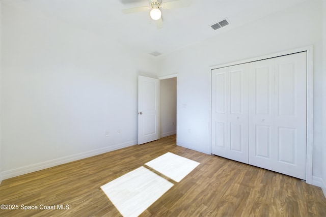 unfurnished bedroom with hardwood / wood-style flooring, ceiling fan, and a closet