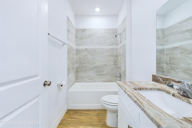 full bathroom with tiled shower / bath combo, toilet, wood-type flooring, and vanity