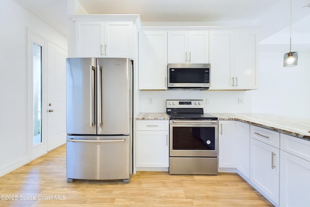 kitchen with light stone counters, white cabinets, and appliances with stainless steel finishes