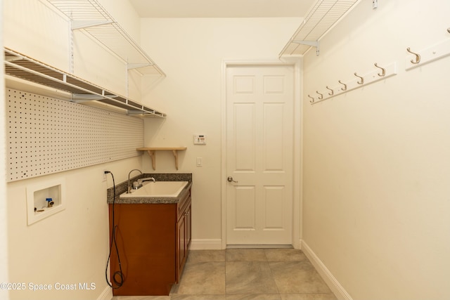 laundry room featuring hookup for a washing machine, sink, light tile patterned floors, and cabinets