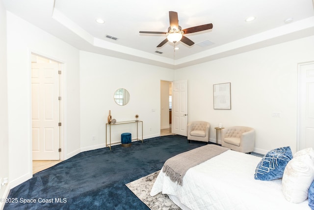 bedroom featuring carpet flooring, ceiling fan, and a raised ceiling