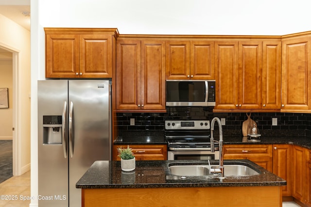 kitchen featuring appliances with stainless steel finishes, sink, light tile patterned floors, and dark stone countertops