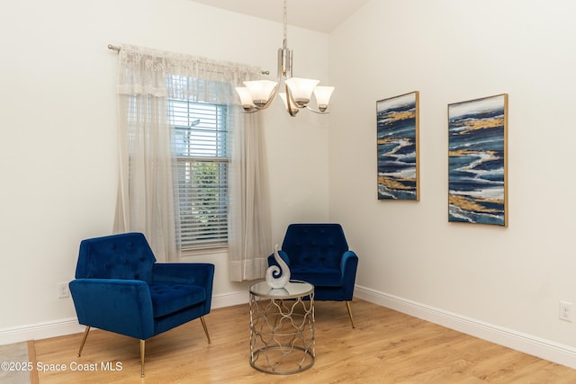 sitting room with hardwood / wood-style flooring and a notable chandelier