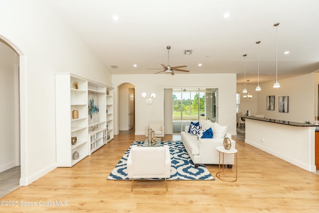 living room featuring light hardwood / wood-style floors, ceiling fan, and lofted ceiling