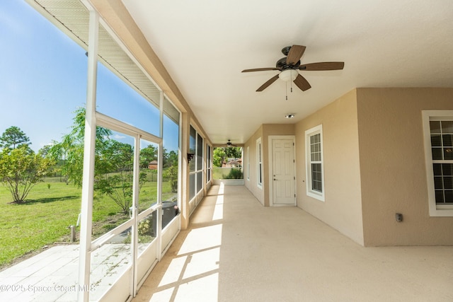 unfurnished sunroom with ceiling fan