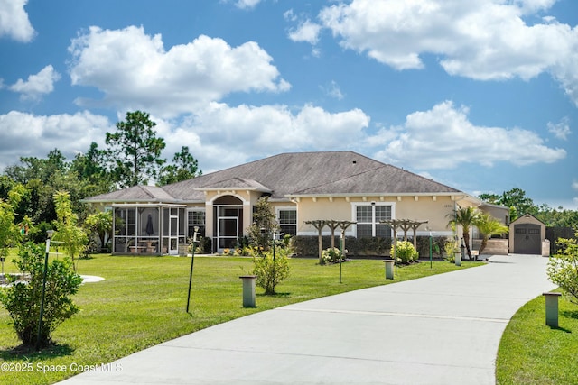 view of front facade with a pergola, a shed, a sunroom, and a front yard