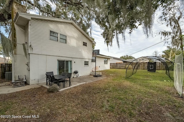 rear view of property with central AC, a patio area, and a yard