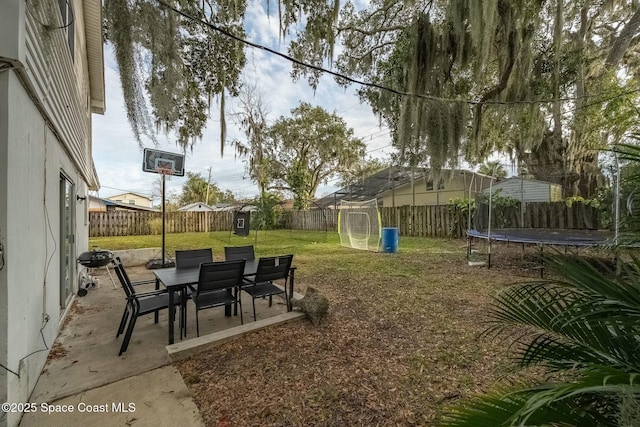 view of yard with a trampoline and a patio