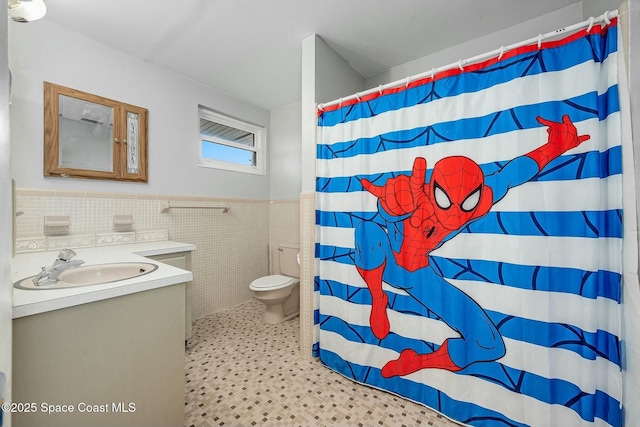 bathroom featuring tile walls, toilet, vanity, and walk in shower