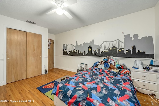 bedroom featuring ceiling fan, a closet, a textured ceiling, and hardwood / wood-style flooring