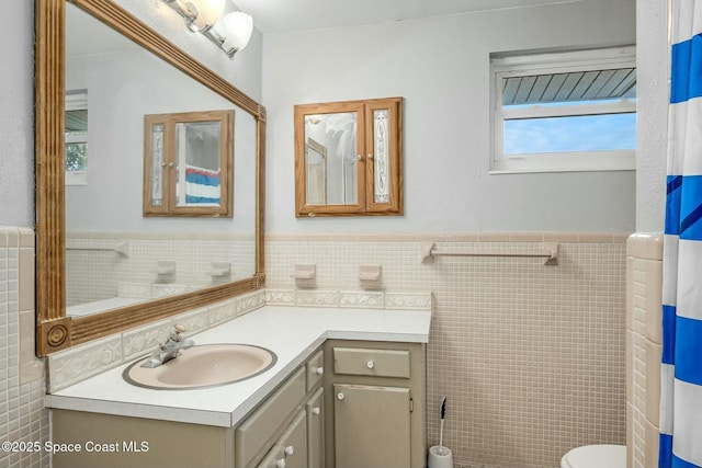 bathroom featuring toilet, tile walls, a shower with curtain, and vanity