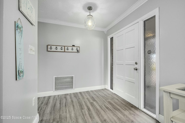 entrance foyer with ornamental molding and light hardwood / wood-style floors